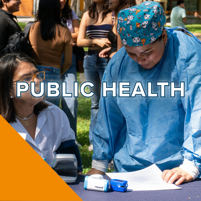 Clinician in blue scrubs consulting woman at outdoor public-health screening table