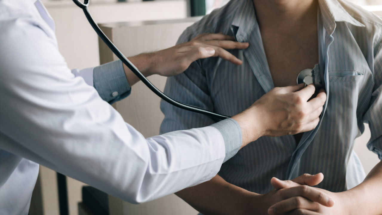 Doctoer using stethoscope on patient to listen to chest